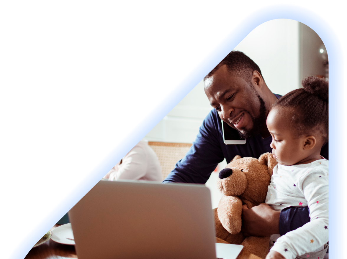 Man on the phone with toddler on lap looking at laptop