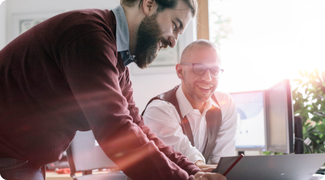Image of two men smiling at computer screen