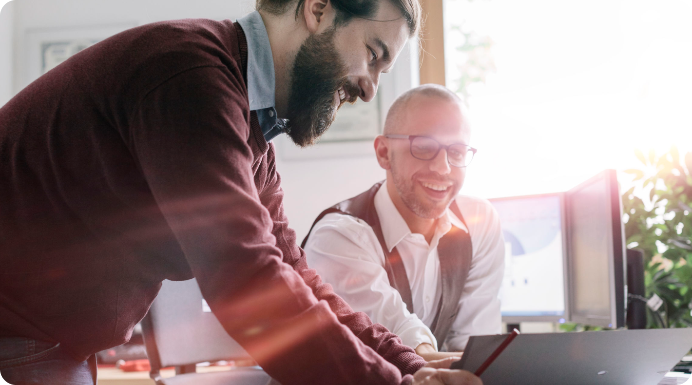Image of two men smiling at computer screen