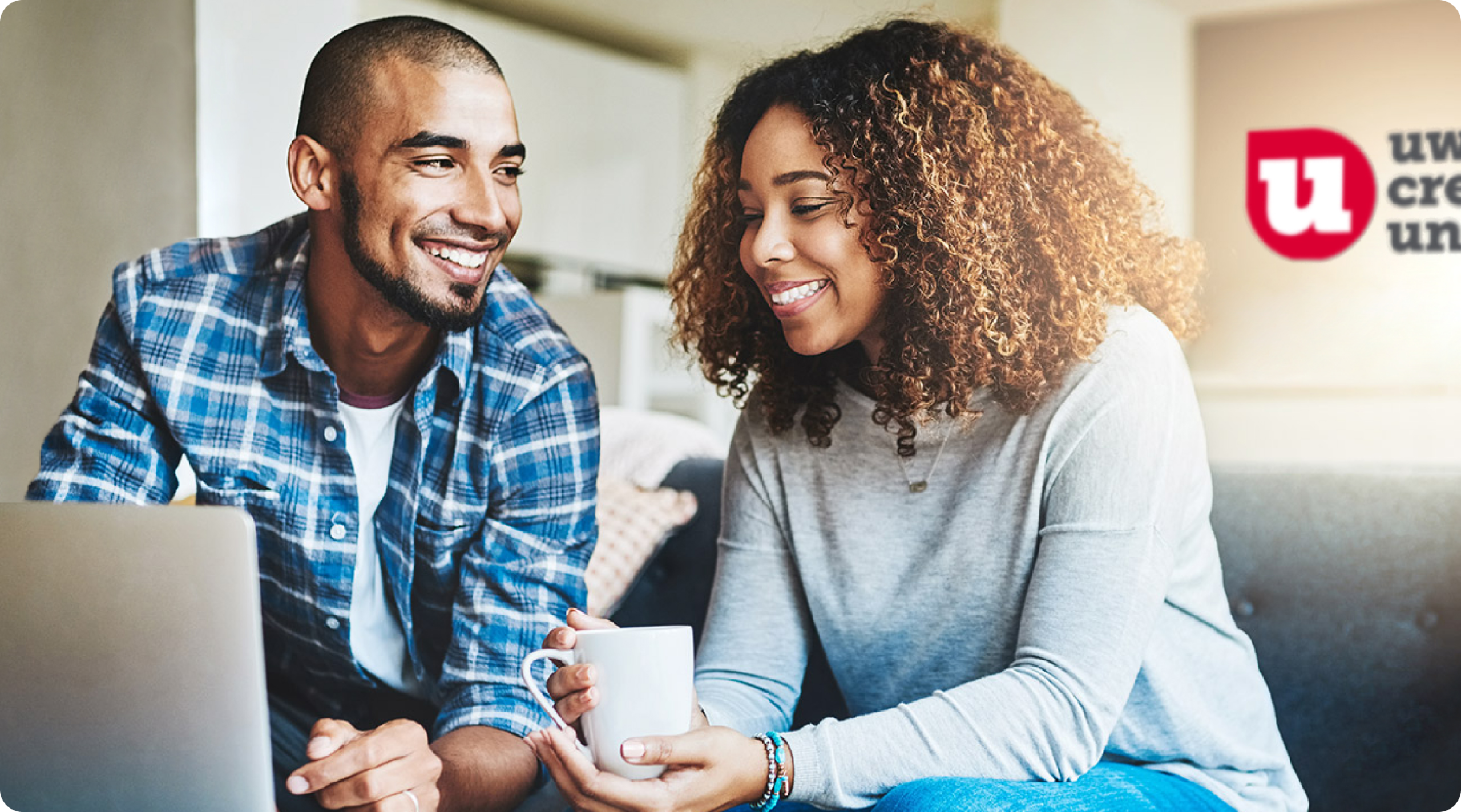 Two people sitting in front of the University of Wisconsin Credit Union logo